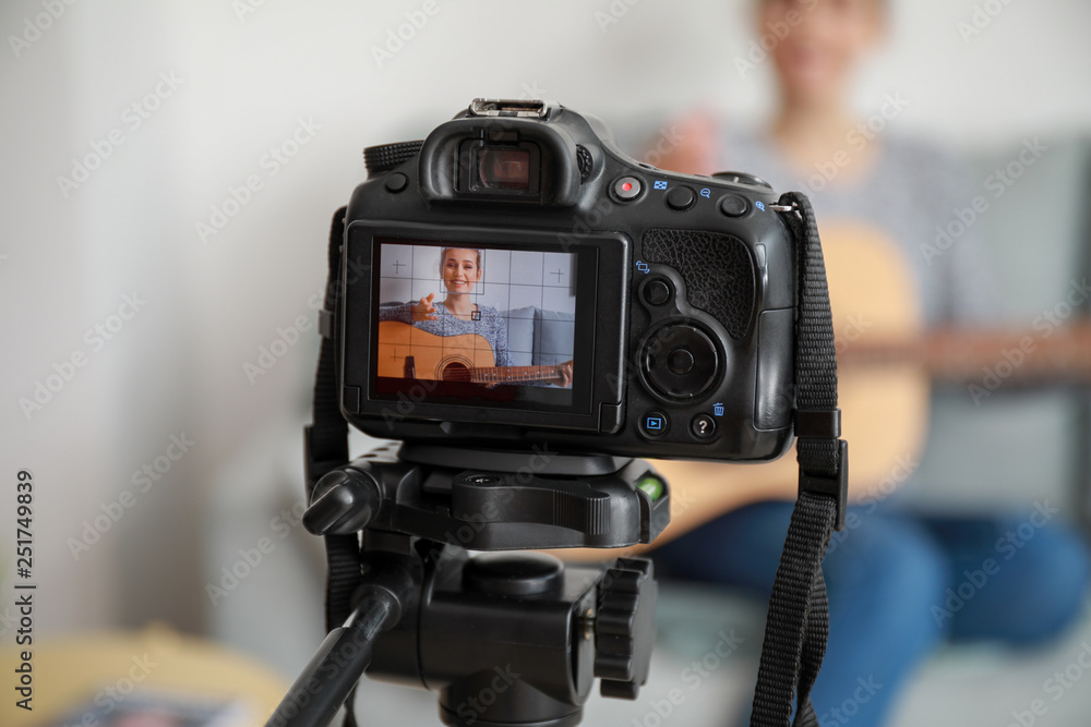 Young female musician recording video indoors