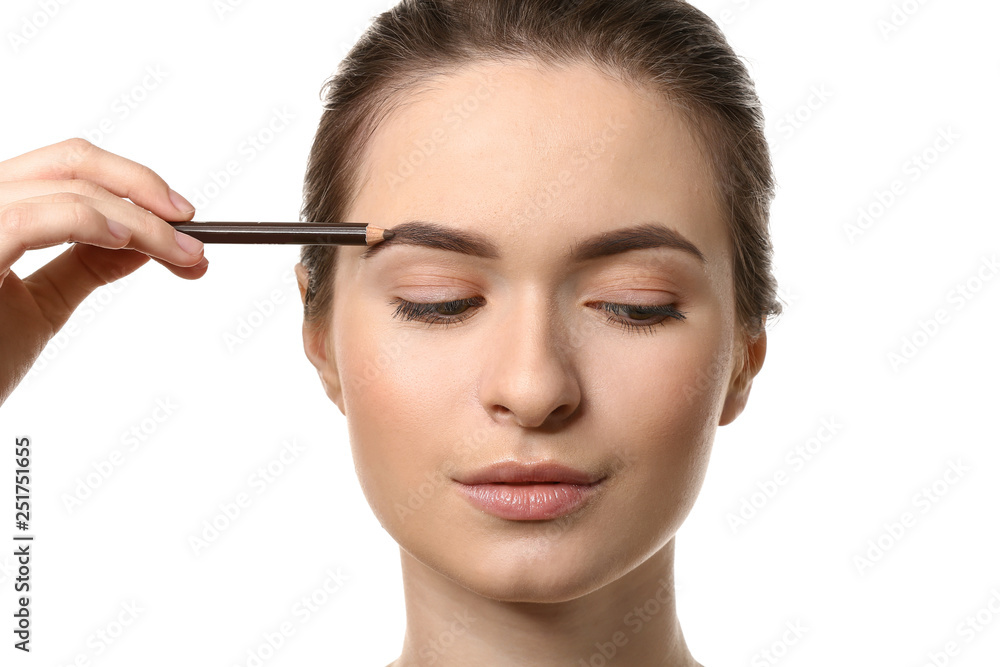 Young woman undergoing eyebrow correction procedure on white background