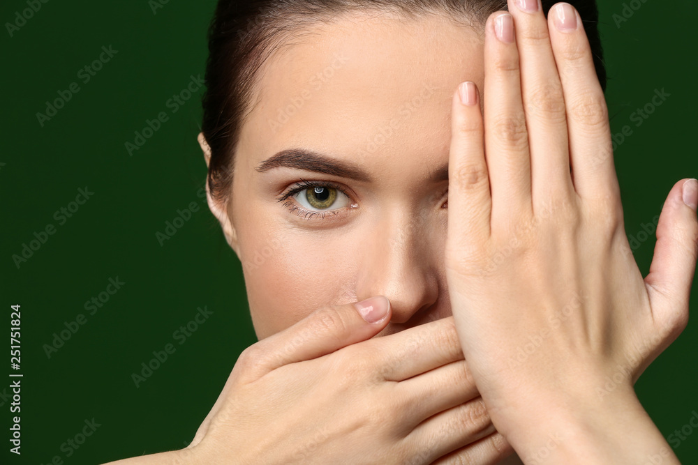 Young woman with beautiful eyebrows on color background