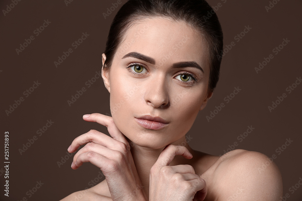 Young woman with beautiful eyebrows on color background