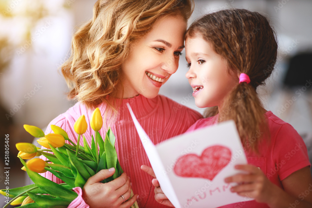 happy mothers day! child daughter   gives mother a bouquet of flowers and postcard.