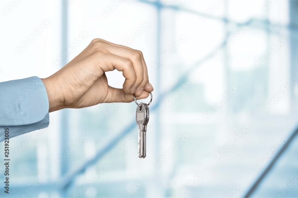 House key in hand on blurred background