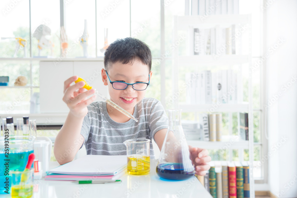 Young asian schoolboy doing chemistry experiment in laboratory classroom. Education concept.