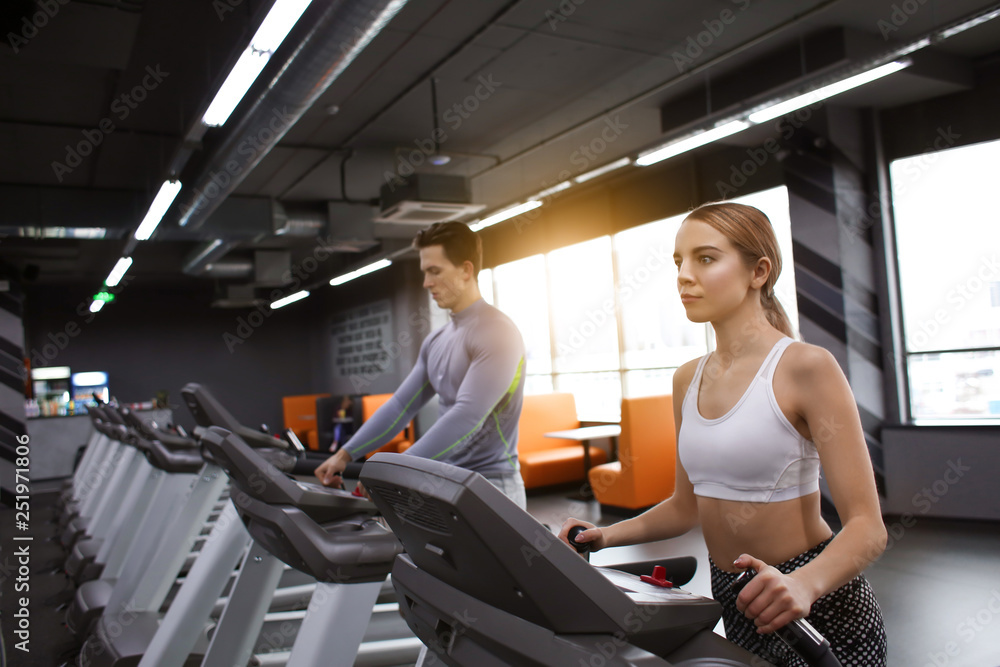 Young sporty woman and man training in modern gym