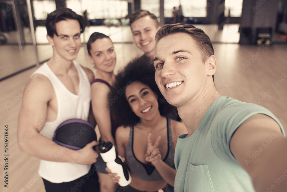 Group of sportive people taking selfie in gym