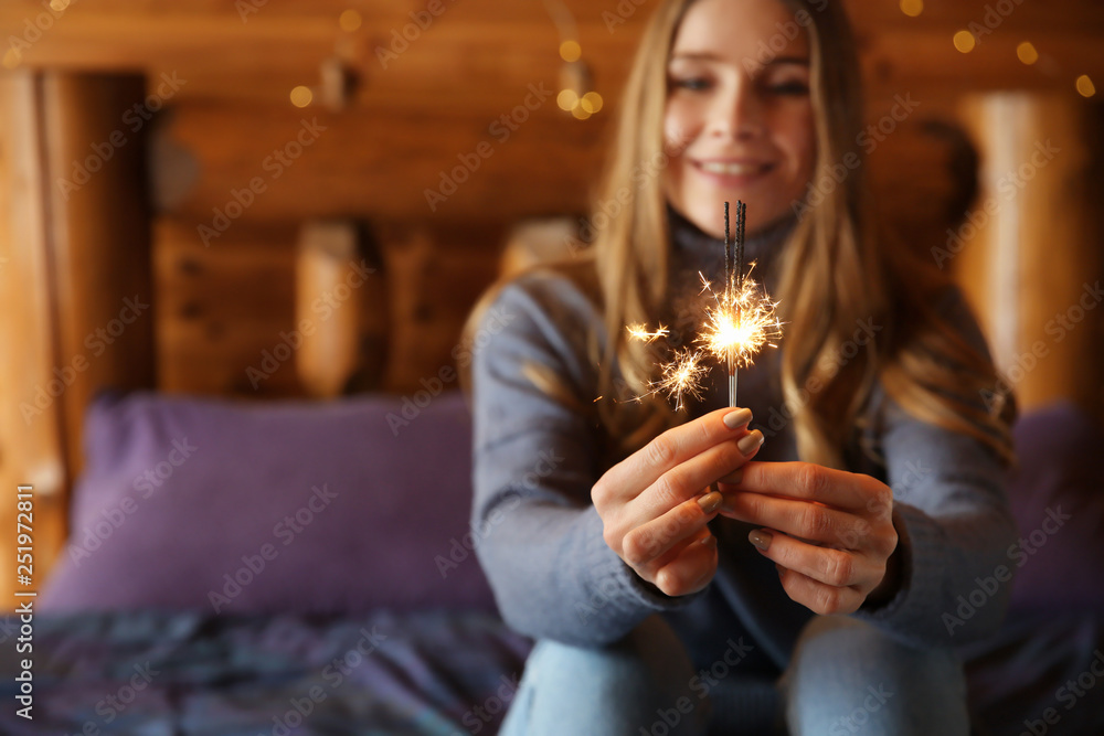 Young woman with sparklers at home