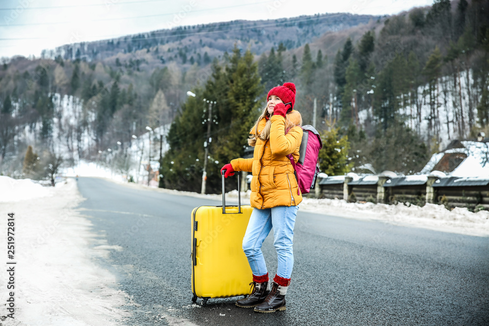 女性旅行者在冬季度假胜地打电话