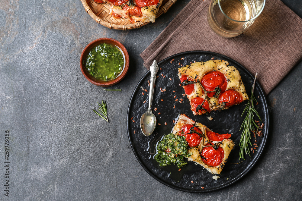 Tasty Italian focaccia and basil sauce on grey table