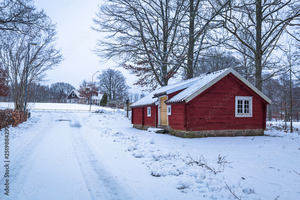 Winter scenery with red wooden house  in Sweden at dawn