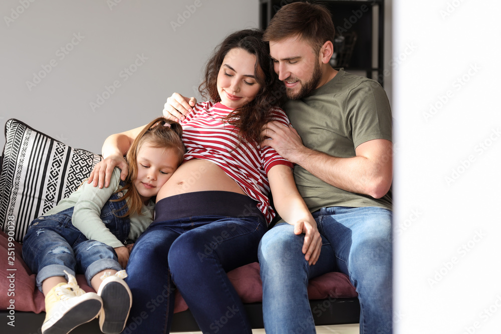 Happy family expecting baby resting at home