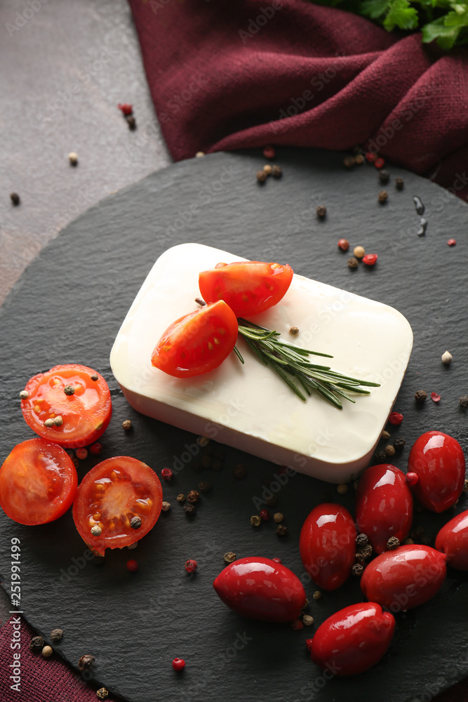 Tasty feta cheese, olives and tomatoes on slate plate