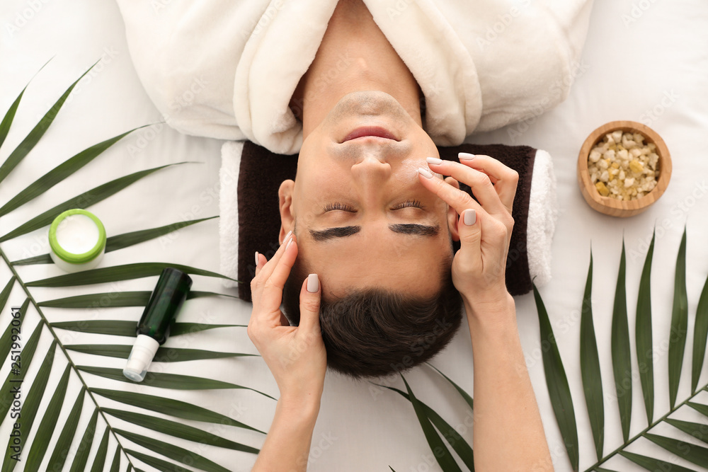 Man receiving face massage in beauty salon