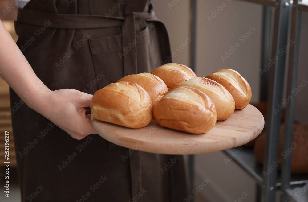 Female chef with freshly baked buns in kitchen