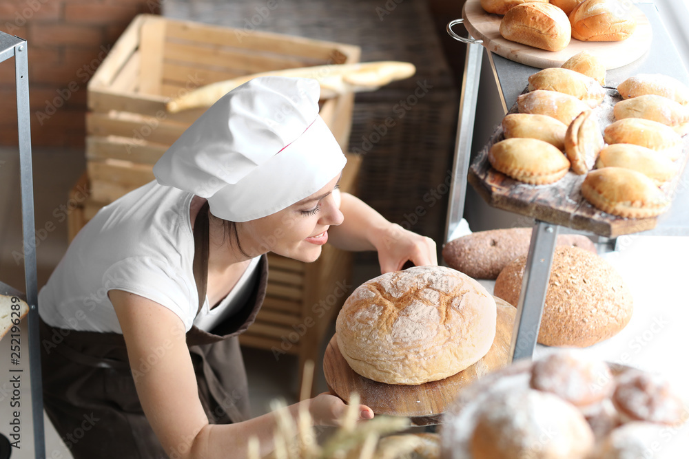 Female chef with freshly baked bread in kitchen