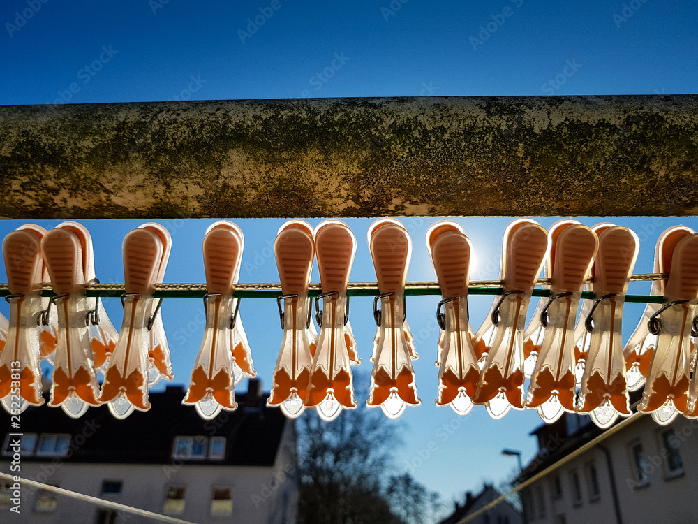 Close up of pegs for clothes on a line in front of the clear blue sky