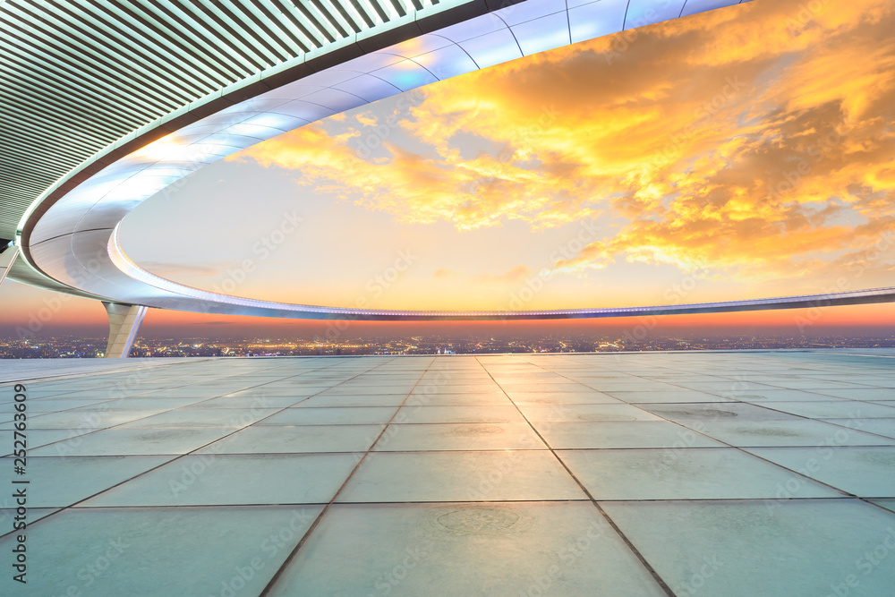 Empty square floor and modern city skyline with buildings at sunset