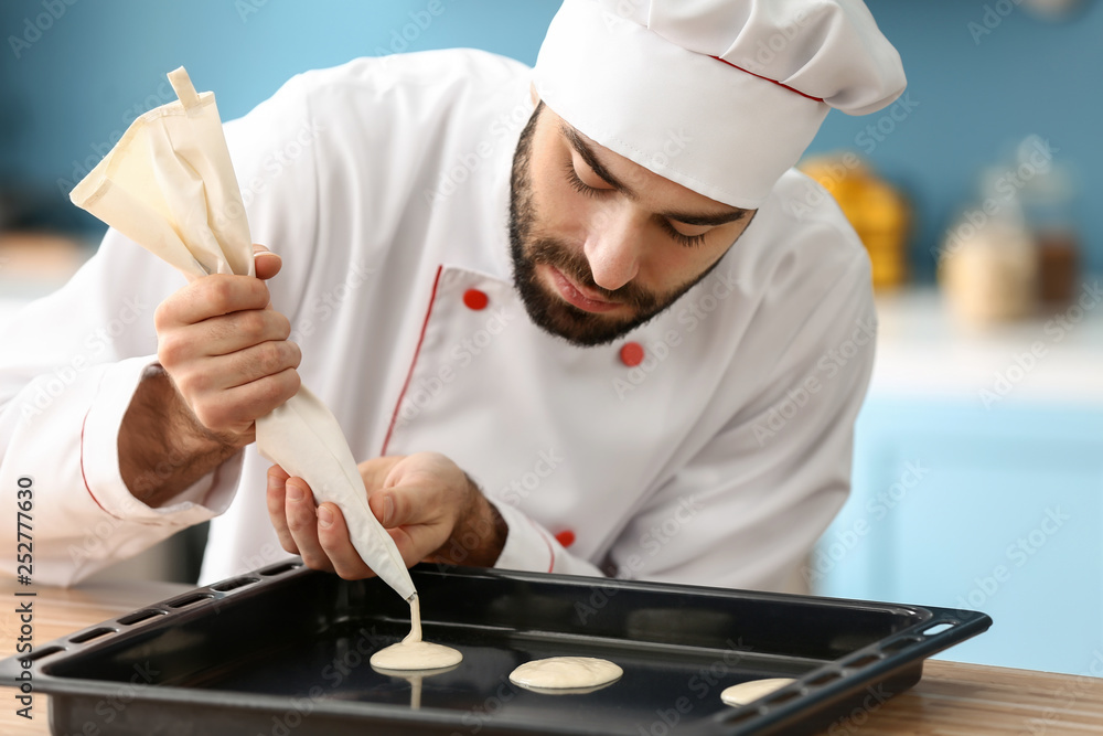 Male confectioner cooking tasty dessert in kitchen