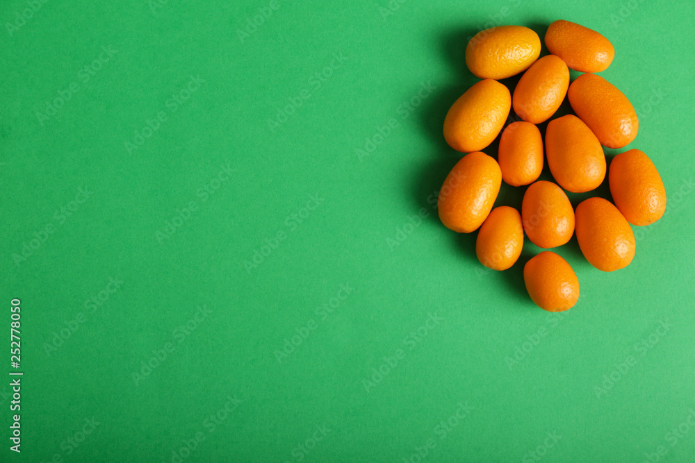 Delicious kumquat fruit on color background