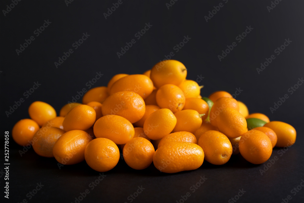 Delicious kumquat fruit on dark background