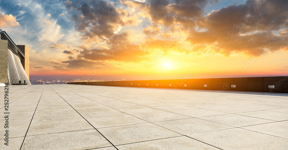 Empty square floor and modern city skyline with buildings at sunset