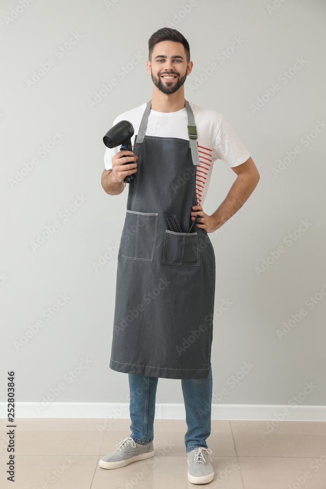 Male hairdresser near light wall