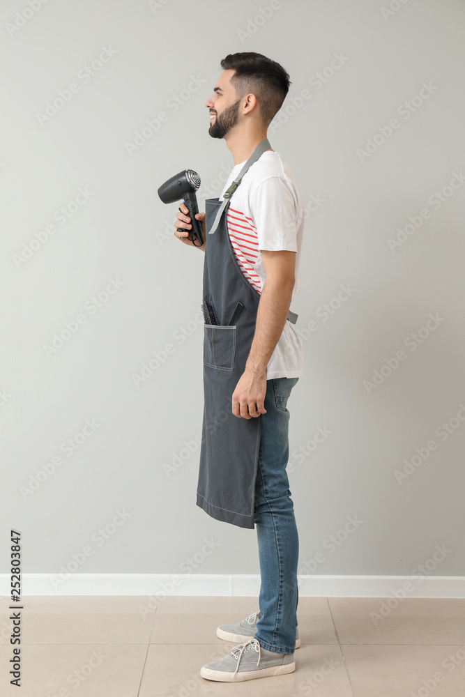 Male hairdresser near light wall