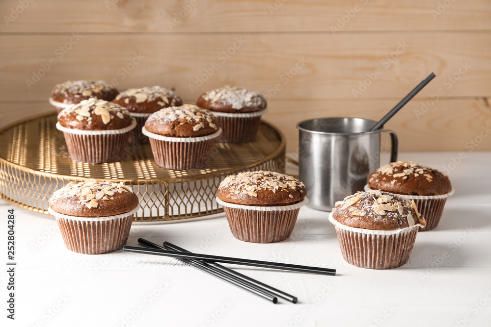 Tasty almond muffins on white table