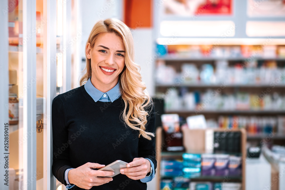 一个美丽的金发女人在商店里看着相机的肖像。