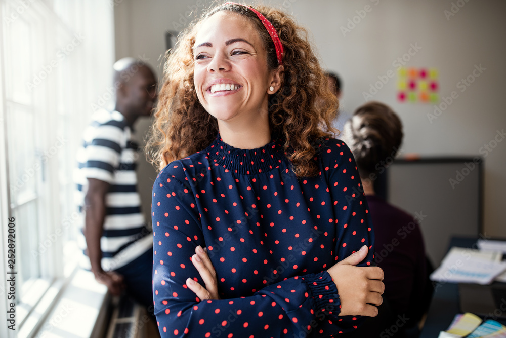 Laughing young designer standing in an office after a meeting