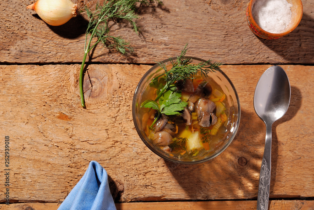 Mushroom soup view from the top, on a wooden background in a glass bowl.