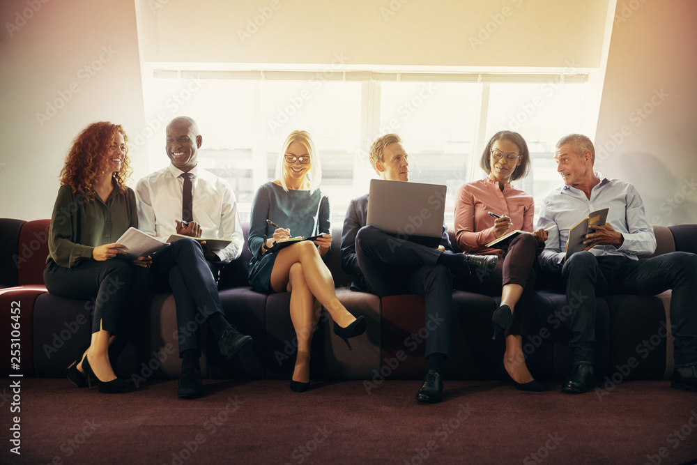 Smiling group of diverse businesspeople sitting on an office sof