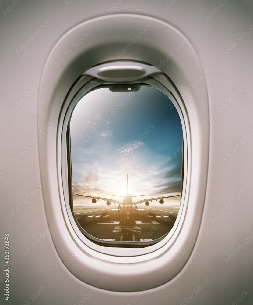 Airplane window view to runway with huge airplane