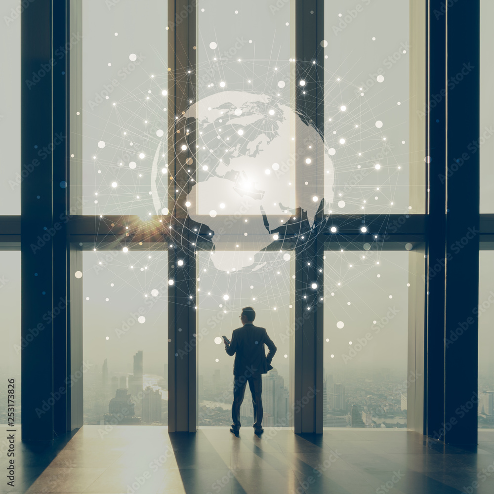 Business man stand by glass window in tall building with background of city