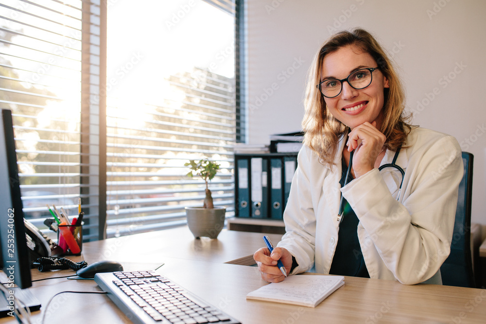 Smiling female doctor sitting her office desk