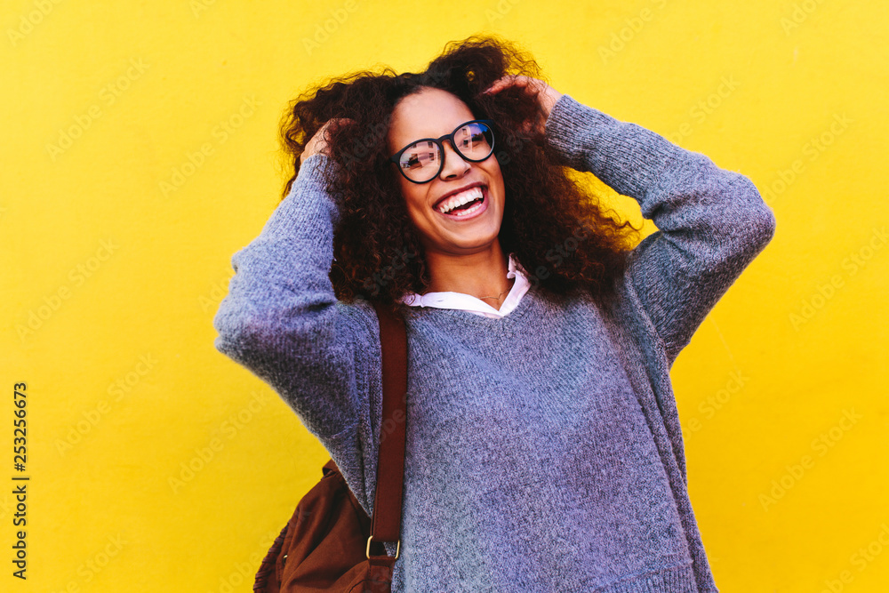 Cheerful female traveler on yellow background