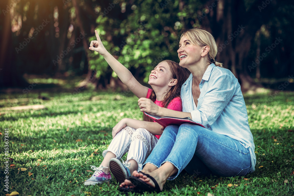 Relaxed happy mother and little kid daughter in outdoors public park. Parenthood and child concept.