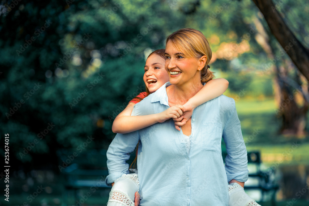 Relaxed happy mother and little kid daughter in outdoors public park. Parenthood and child concept.