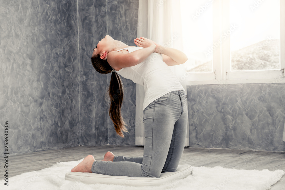 Young beautiful woman do yoga exercise on carpet at home living room. Healthy lifestyle and relaxati