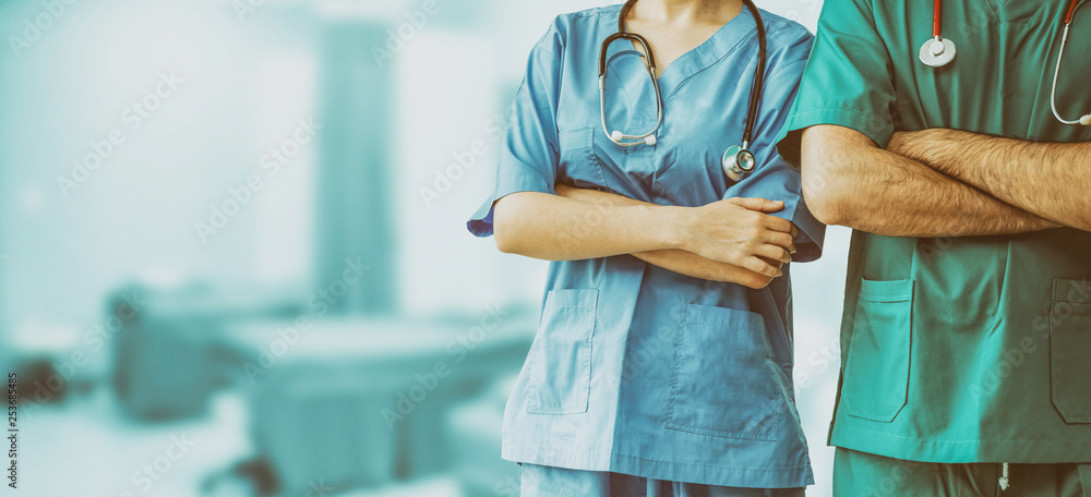 Two hospital staffs - surgeon, doctor or nurse standing with arms crossed in the hospital. Medical h