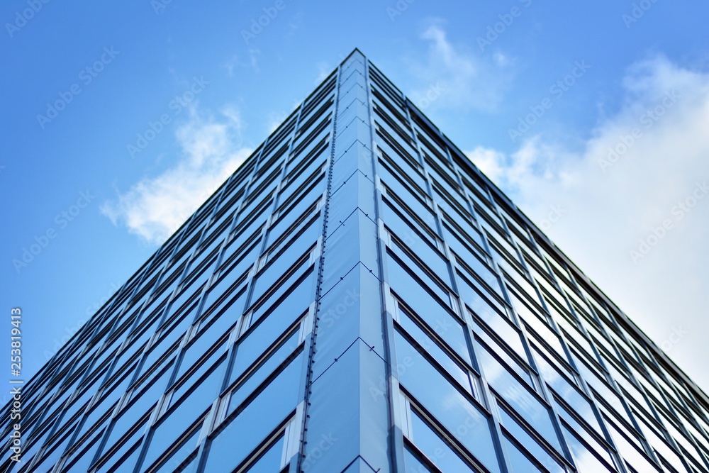 Surface of glass building with the reflection of clouds