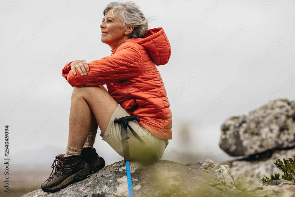 Female trekker sitting on a rock relaxing