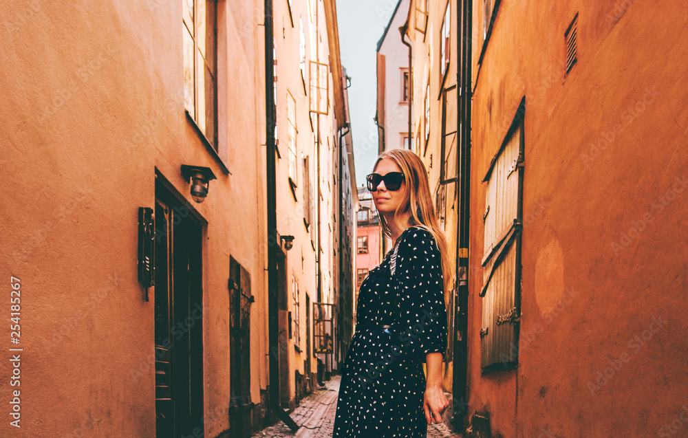 Blonde woman walking in Stockholm  traveling alone fashion lifestyle summer vacations in Sweden old 