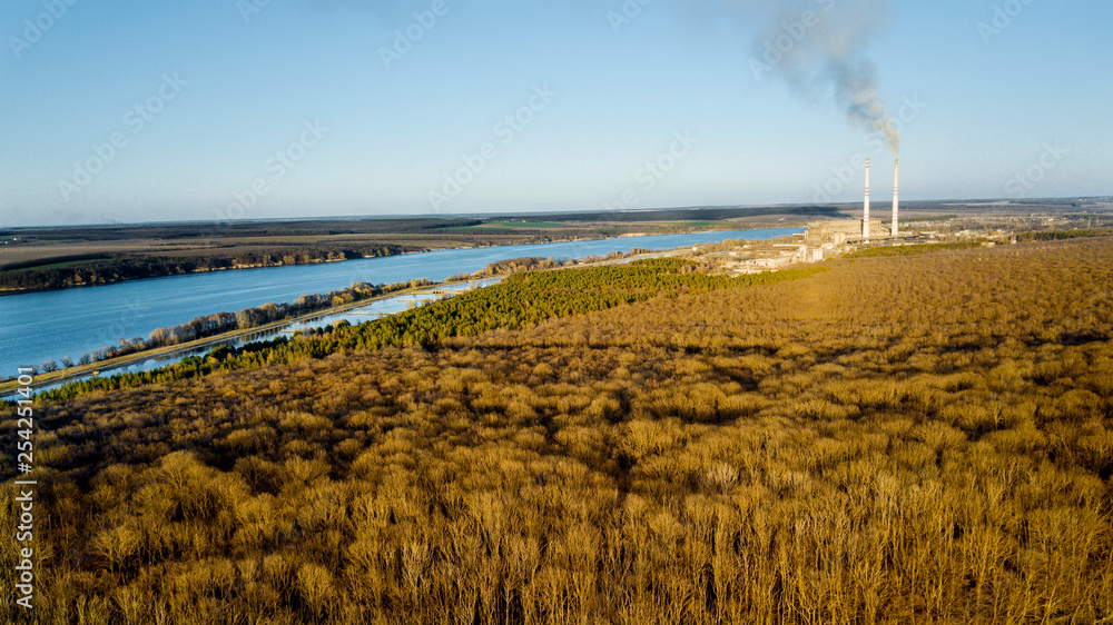 Aerial view of the forest in early spring, blue river and fields under the clear sky. Natural backgr