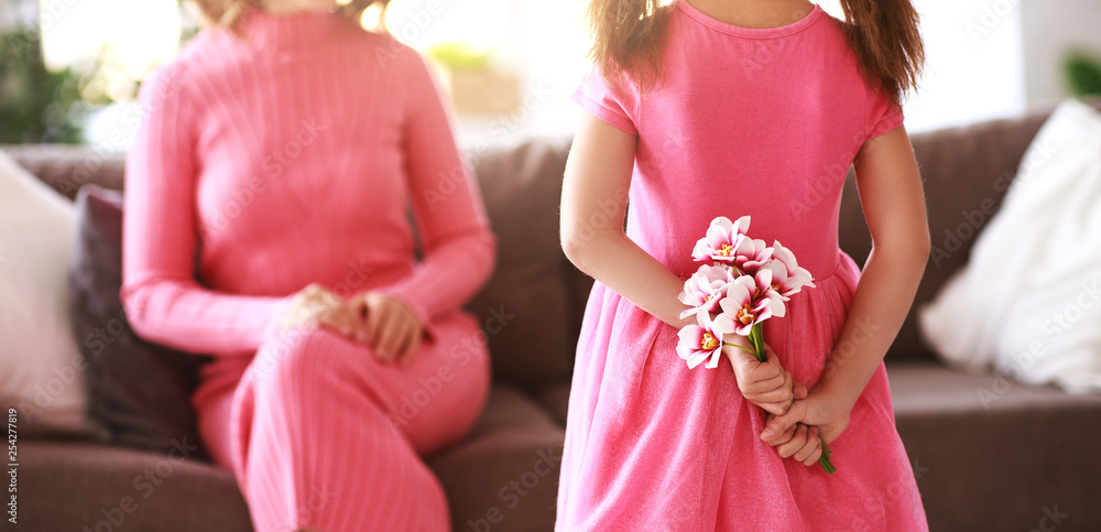 happy mothers day! child daughter   gives mother a bouquet of flowers and postcard.