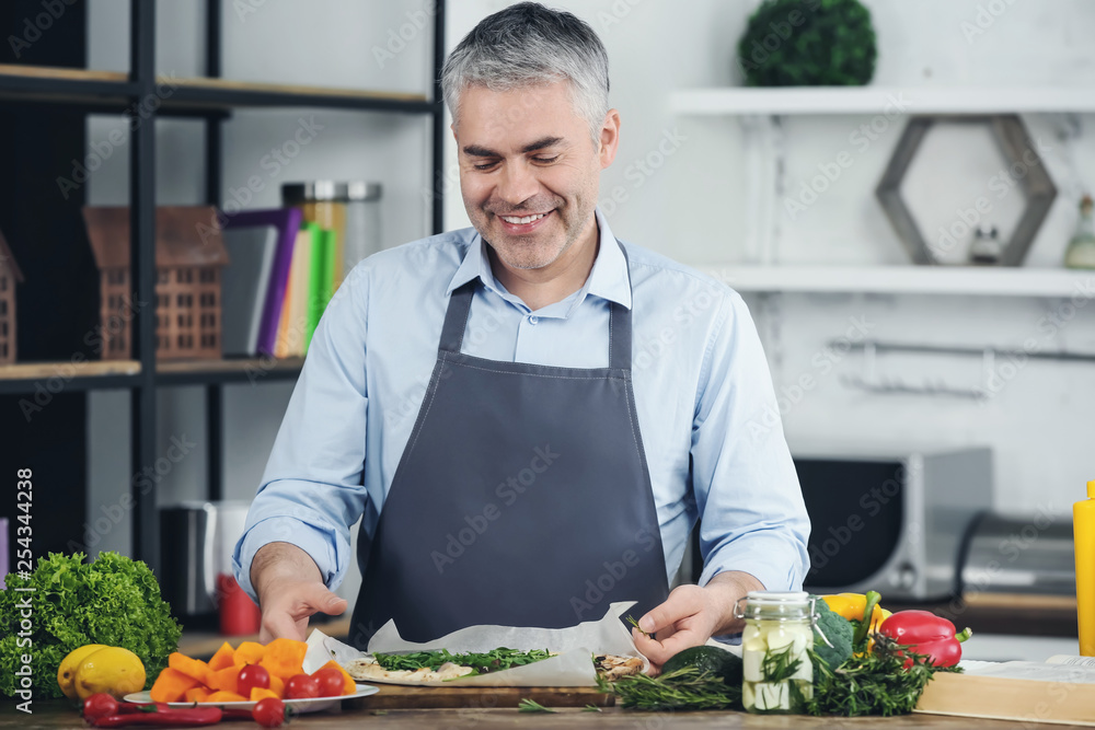 Mature man cooking tasty pizza at home