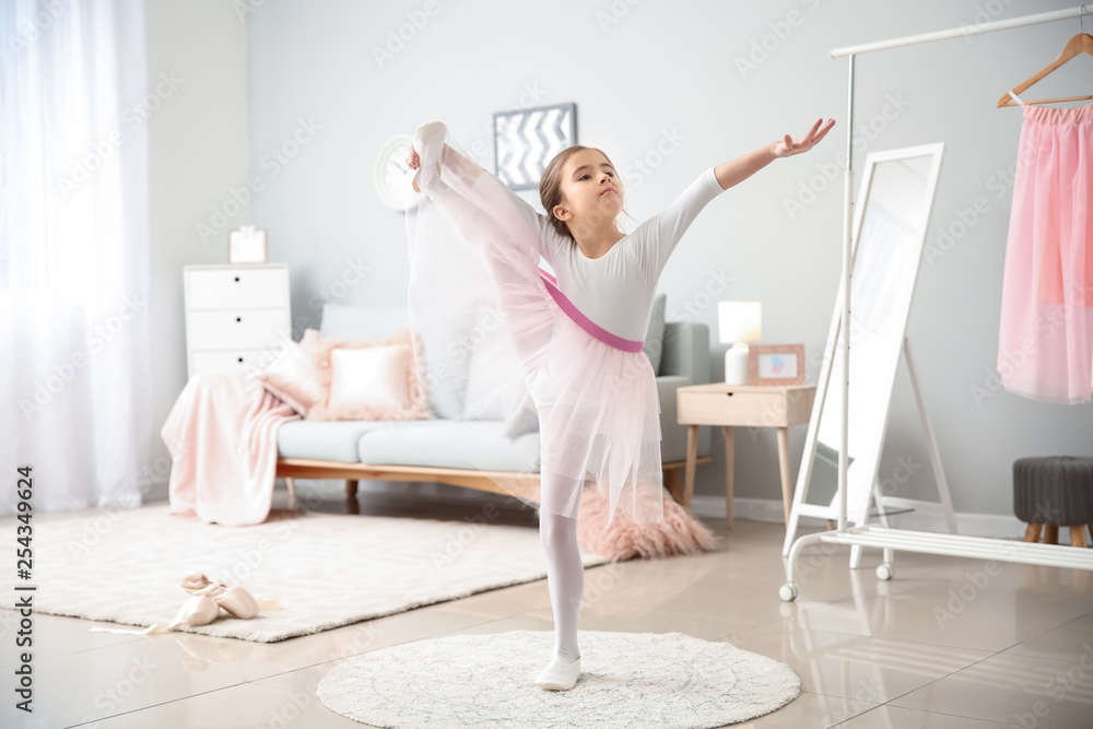 Cute little ballerina dancing at home