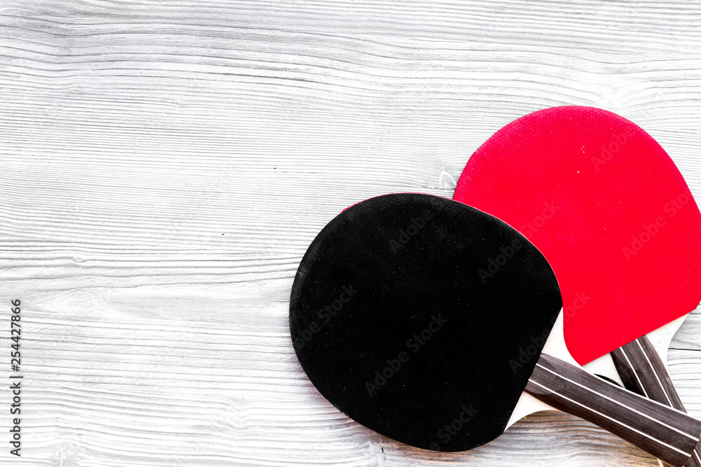 black racket for ping pong ball wooden background top view