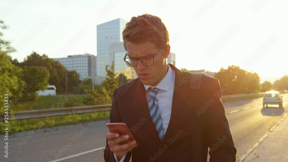 LENS FLARE: Worried yuppie reading a long text message on his way home from work