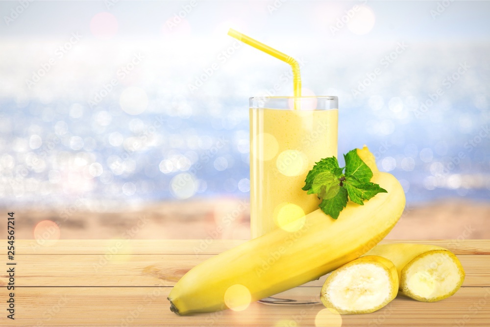 Tasty banana milkshake on wooden table