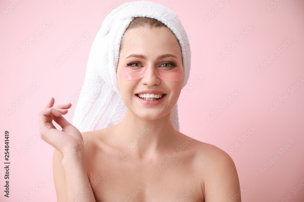 Young woman with under-eye patches on color background